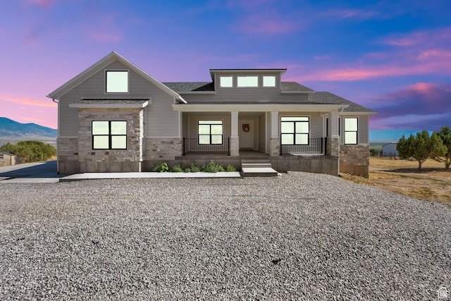 2423 W Cedarline Loop, Stockton, UT 84071 - view of front of house featuring stone siding, covered porch, and roof with shingles