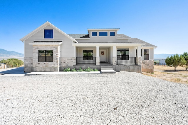 2423 W Cedarline Loop, Stockton, UT 84071 - view of front of property with a mountain view, stone siding, a porch, and roof with shingles