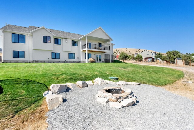 2423 W Cedarline Loop, Stockton, UT 84071 - rear view of house featuring a balcony, an outdoor fire pit, a yard, and stucco siding