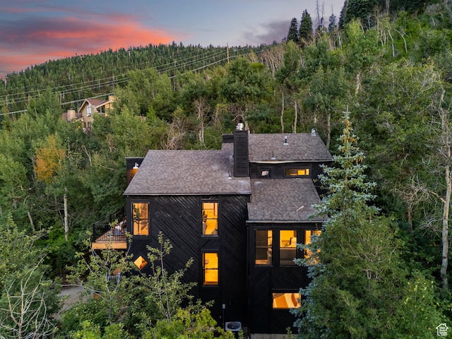 947 Northstar Dr, Park City, UT 84060 - back of house featuring a balcony, a forest view, a chimney, and a shingled roof