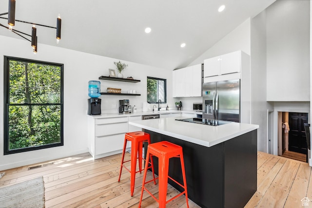 947 Northstar Dr, Park City, UT 84060 - kitchen with stainless steel fridge, white cabinets, open shelves, light wood-type flooring, and light countertops