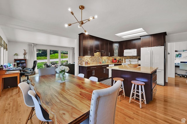 4445 Fillmore Ave, Ogden, UT 84403 - dining space with light wood-type flooring, a chandelier, and an office area