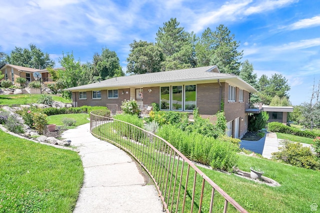 4445 Fillmore Ave, Ogden, UT 84403 - ranch-style house with brick siding, a garage, and a front lawn