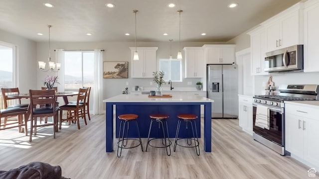 165 S 2800 E Unit 102, Spanish Fork, UT 84660 - kitchen with stainless steel appliances, light wood-type flooring, a center island, recessed lighting, and a breakfast bar