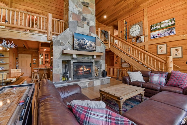 8581 Shingle Mill Dr, Oakley, UT 84055 - living area featuring a high ceiling, wood walls, wood ceiling, a fireplace, and stairs