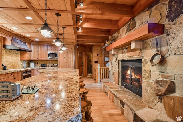 8581 Shingle Mill Dr, Oakley, UT 84055 - kitchen with appliances with stainless steel finishes, a wood ceiling with exposed beams, wall chimney range hood, light wood-style floors, and decorative light fixtures