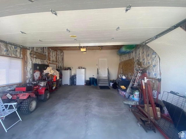 6689 W 7625 S, Myton, UT 84052 - garage featuring a garage door opener and freestanding refrigerator
