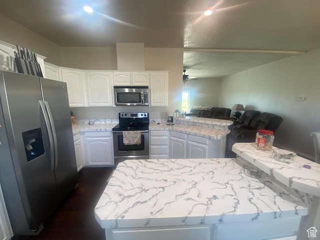 6689 W 7625 S, Myton, UT 84052 - kitchen with appliances with stainless steel finishes, a peninsula, white cabinets, and light stone countertops