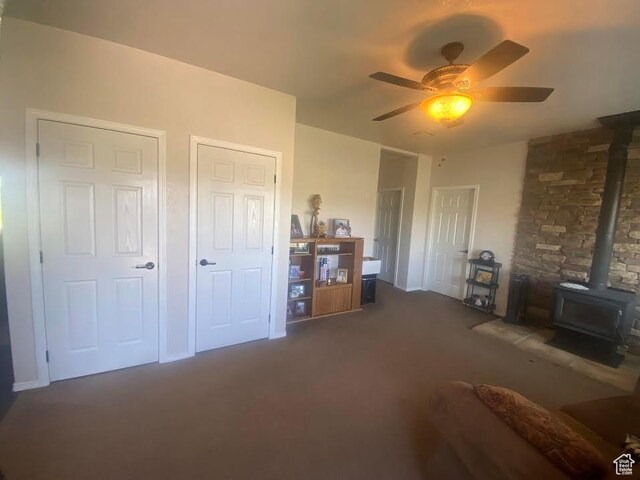 6689 W 7625 S, Myton, UT 84052 - carpeted living area featuring a wood stove and a ceiling fan