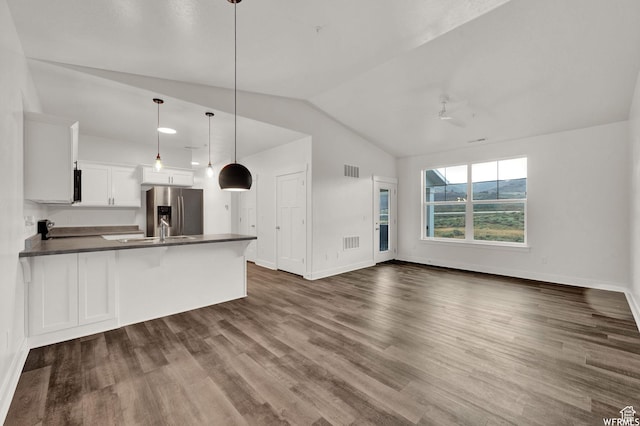 14708 S Astin Ln Unit 302, Herriman, UT 84096 - kitchen featuring stainless steel fridge with ice dispenser, dark countertops, a peninsula, lofted ceiling, and white cabinets