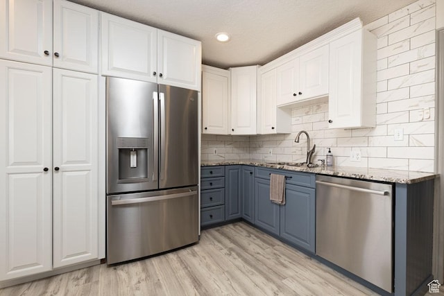 1444 N 3775 W, Cedar City, UT 84721 - kitchen featuring stainless steel appliances, light stone counters, white cabinets, light wood-style flooring, and blue cabinetry