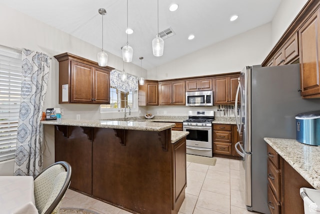 763 W 100 N, Hurricane, UT 84737 - kitchen with appliances with stainless steel finishes, a breakfast bar, light stone counters, a peninsula, and decorative light fixtures