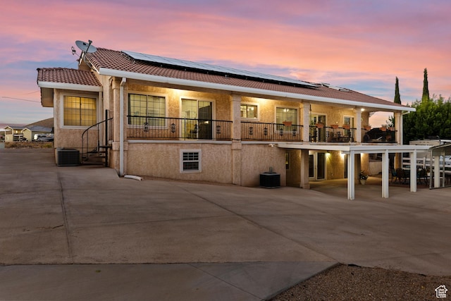 763 W 100 N, Hurricane, UT 84737 - back of property at dusk featuring a balcony, roof mounted solar panels, a tiled roof, and stucco siding
