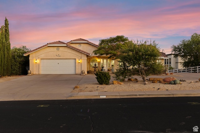 763 W 100 N, Hurricane, UT 84737 - view of front facade with driveway, a garage, stucco siding, and a tiled roof