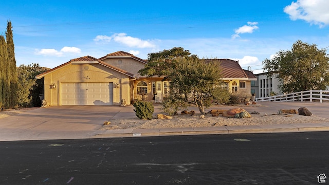 763 W 100 N, Hurricane, UT 84737 - mediterranean / spanish-style home featuring a garage, a tile roof, concrete driveway, and stucco siding