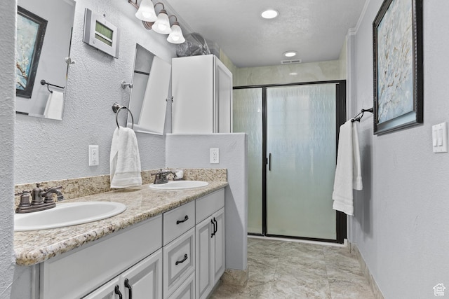 763 W 100 N, Hurricane, UT 84737 - bathroom featuring a shower stall, double vanity, and a textured wall