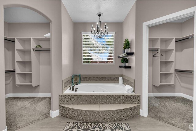 3334 W 2700 S, Hurricane, UT 84737 - bathroom with a whirlpool tub, a spacious closet, a chandelier, and a textured ceiling
