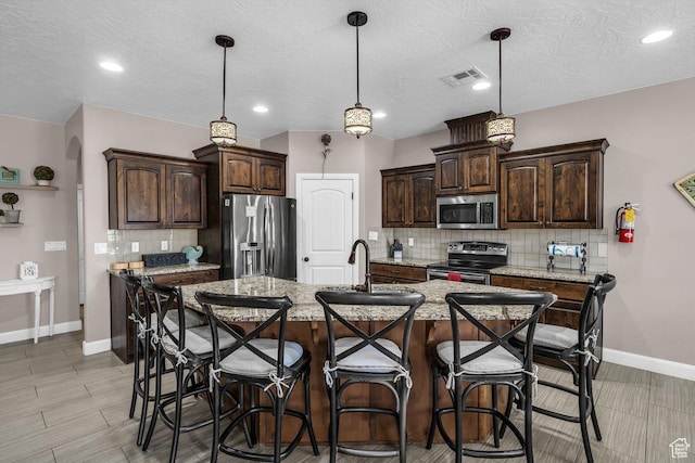 3334 W 2700 S, Hurricane, UT 84737 - kitchen featuring stainless steel appliances, dark brown cabinetry, tasteful backsplash, a breakfast bar area, and recessed lighting