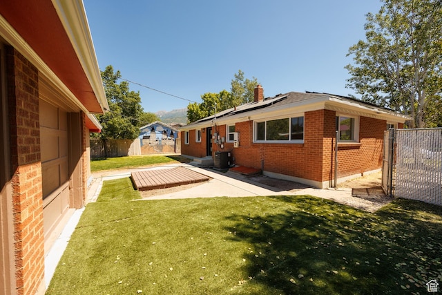 875 N 50 W, Orem, UT 84057 - back of house with brick siding, a patio area, roof mounted solar panels, a fenced backyard, and a chimney