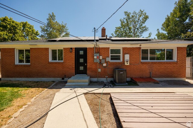 875 N 50 W, Orem, UT 84057 - view of front of home featuring brick siding, solar panels, entry steps, and a chimney