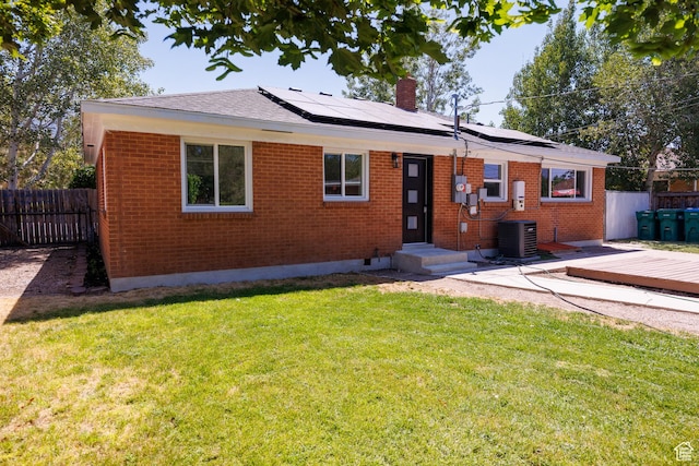 875 N 50 W, Orem, UT 84057 - rear view of property featuring brick siding, a chimney, solar panels, a wooden deck, and roof with shingles
