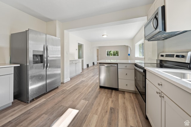 726 E 29th S, Ogden, UT 84403 - kitchen featuring appliances with stainless steel finishes, a peninsula, light wood-style floors, and light countertops