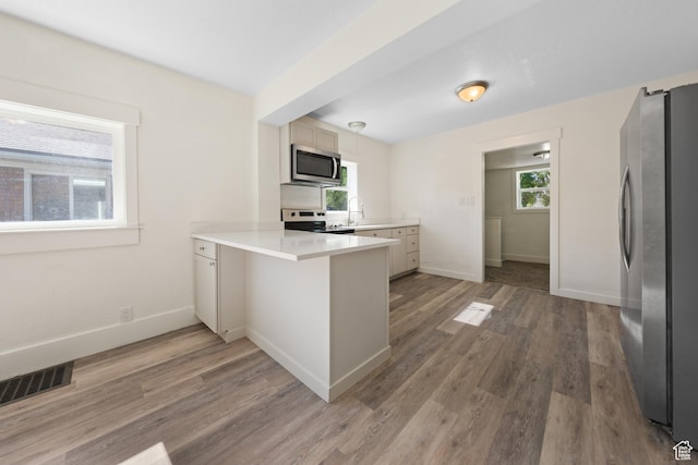 726 E 29th S, Ogden, UT 84403 - kitchen featuring appliances with stainless steel finishes, a peninsula, light countertops, and light wood-type flooring