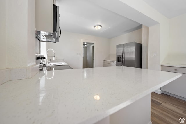 726 E 29th S, Ogden, UT 84403 - kitchen featuring stainless steel fridge, a peninsula, light stone countertops, and dark wood-style flooring