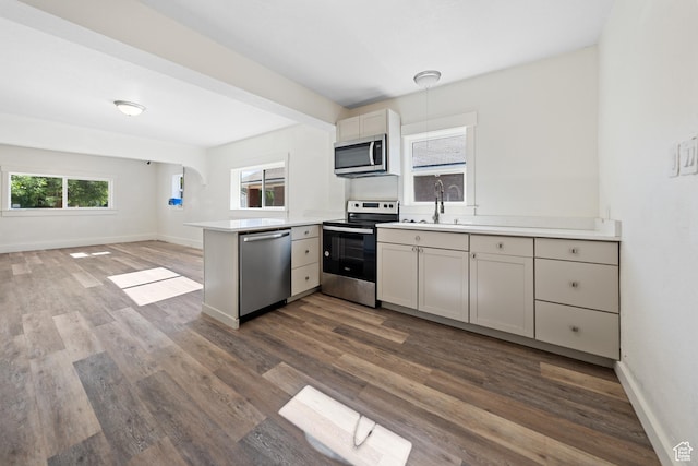 726 E 29th S, Ogden, UT 84403 - kitchen with stainless steel appliances, a peninsula, plenty of natural light, and dark wood finished floors