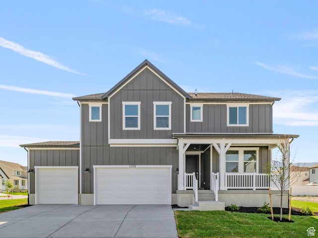 1844 E Bison Dr N Unit B229, Eagle Mountain, UT 84005 - view of front of home featuring covered porch, concrete driveway, a front yard, an attached garage, and a shingled roof