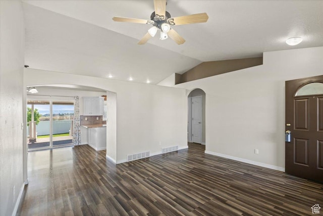 845 S 1150 E, Preston, ID 83263 - unfurnished living room featuring arched walkways, lofted ceiling, dark wood-type flooring, and ceiling fan