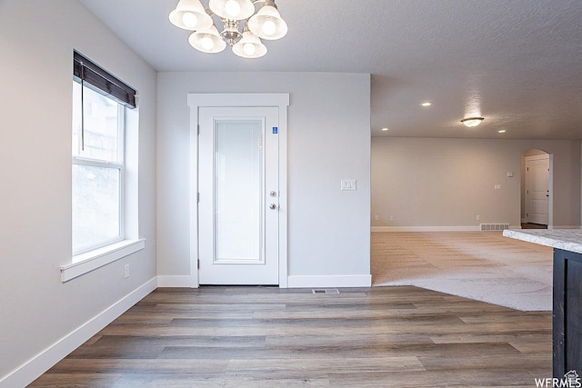 124 N Peach St, Santaquin, UT 84655 - entryway with arched walkways, a chandelier, wood finished floors, a textured ceiling, and recessed lighting