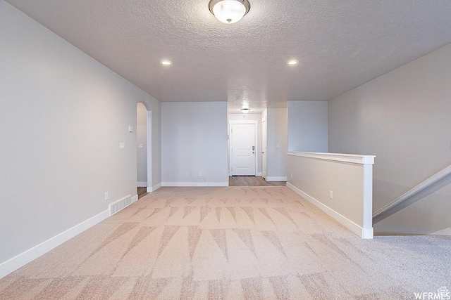 124 N Peach St, Santaquin, UT 84655 - below grade area with arched walkways, a textured ceiling, carpet, and recessed lighting