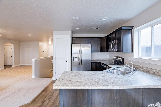 124 N Peach St, Santaquin, UT 84655 - kitchen featuring appliances with stainless steel finishes, light countertops, a textured ceiling, arched walkways, and recessed lighting