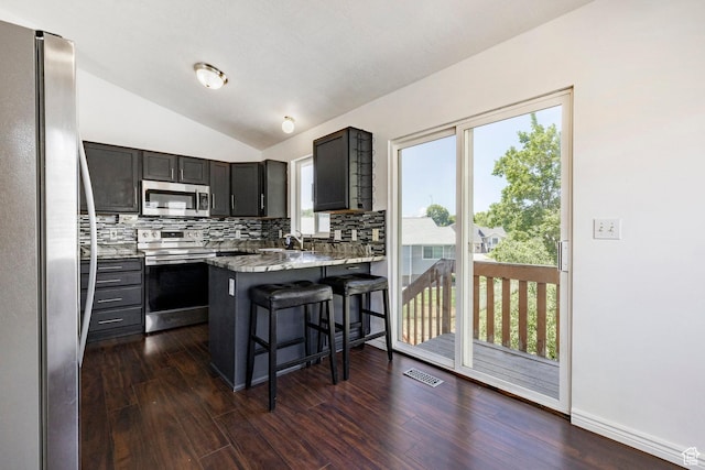 902 W 4200 S, Riverdale, UT 84405 - kitchen with stainless steel appliances, backsplash, lofted ceiling, a peninsula, and a kitchen breakfast bar