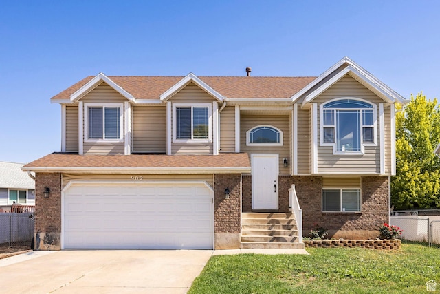 902 W 4200 S, Riverdale, UT 84405 - split foyer home with driveway, a garage, brick siding, and roof with shingles