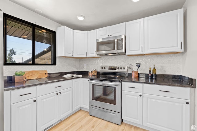 2111 W 5800 S, Roy, UT 84067 - kitchen featuring stainless steel appliances, light wood finished floors, white cabinets, and dark stone countertops