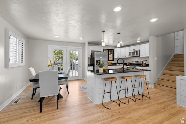 2111 W 5800 S, Roy, UT 84067 - kitchen featuring appliances with stainless steel finishes, dark countertops, white cabinetry, a kitchen breakfast bar, and recessed lighting