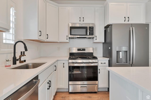 6427 W Arranmore Dr, South Jordan, UT 84009 - kitchen featuring appliances with stainless steel finishes, white cabinetry, light wood-type flooring, and light stone countertops
