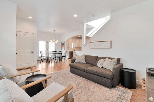 6427 W Arranmore Dr, South Jordan, UT 84009 - living room featuring arched walkways, light wood-style flooring, recessed lighting, and a chandelier