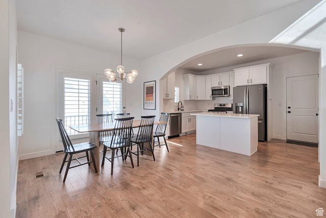 6427 W Arranmore Dr, South Jordan, UT 84009 - dining room with arched walkways, a chandelier, light wood-style flooring, and recessed lighting