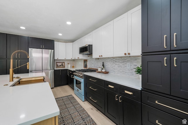 2038 W 8970 S, West Jordan, UT 84088 - kitchen with appliances with stainless steel finishes, white cabinetry, light countertops, backsplash, and recessed lighting
