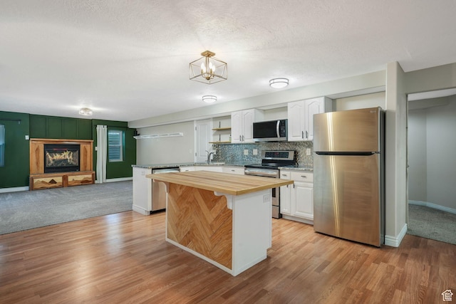 2038 W 8970 S, West Jordan, UT 84088 - kitchen with appliances with stainless steel finishes, wooden counters, white cabinets, and decorative backsplash