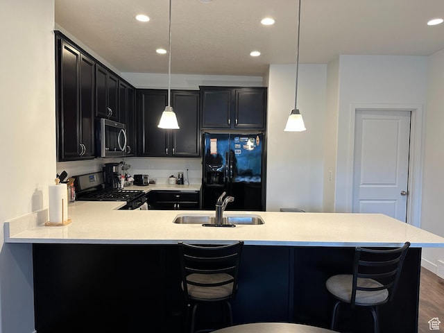 981 W Cyan Valley Way, Bluffdale, UT 84065 - kitchen featuring stainless steel microwave, range with gas cooktop, black fridge, light countertops, and dark cabinets