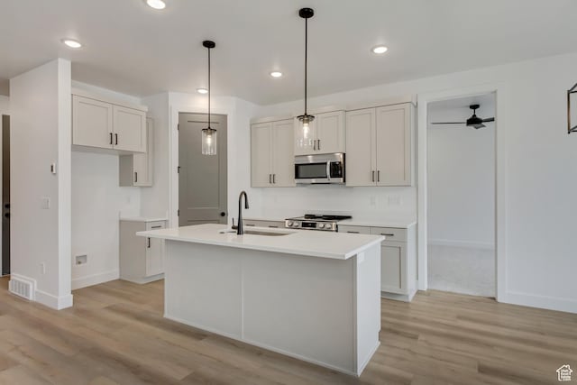 1274 N 1475 E Unit 37, Payson, UT 84651 - kitchen featuring appliances with stainless steel finishes, light wood finished floors, a kitchen island with sink, light countertops, and decorative light fixtures