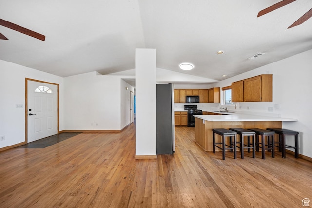 5317 N 2700 W, Cedar City, UT 84721 - kitchen with ceiling fan, black appliances, lofted ceiling, brown cabinets, and light countertops