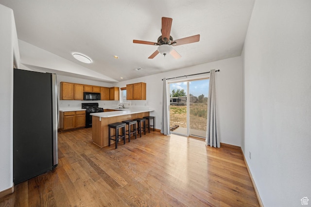 5317 N 2700 W, Cedar City, UT 84721 - kitchen with black appliances, a peninsula, brown cabinets, light wood-style flooring, and light countertops
