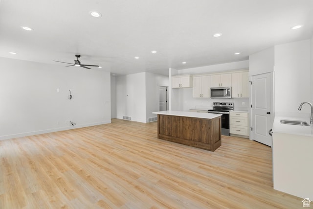 244 E 300 N, Payson, UT 84651 - kitchen featuring appliances with stainless steel finishes, a kitchen island, recessed lighting, light wood-style flooring, and white cabinetry