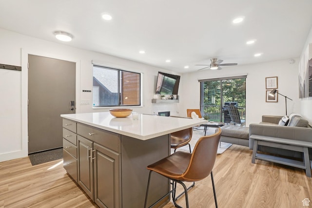 2025 Canyons Resort Dr Unit I1, Park City, UT 84098 - kitchen with open floor plan, light wood-style flooring, ceiling fan, a breakfast bar, and a center island
