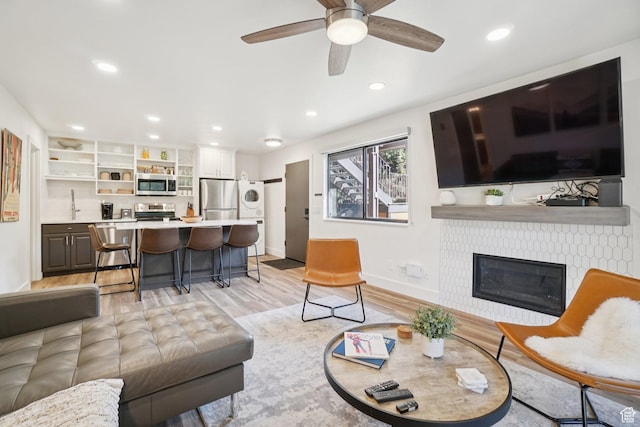 2025 Canyons Resort Dr Unit I1, Park City, UT 84098 - living area featuring stacked washing machine and dryer, light wood-style floors, a ceiling fan, recessed lighting, and a tiled fireplace